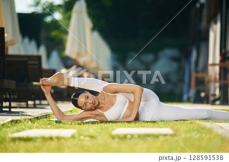 Conception of fitness and flexibility. Young woman in yoga clothes is outdoors 128591538