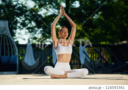 Young woman in yoga clothes is outdoors 128591561