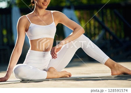 Taking a break, sitting. Young woman in yoga clothes is outdoors 128591574