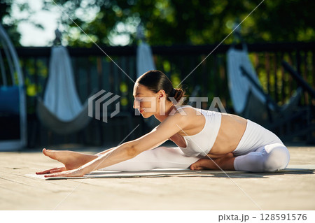 Young woman in yoga clothes is outdoors Young woman in yoga clothes is outdoors 128591576