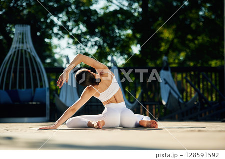 Professional exercises. Young woman in yoga clothes is outdoors 128591592