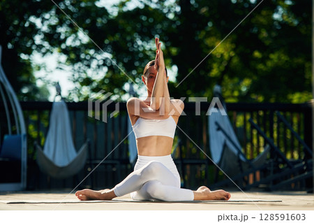 Professional exercises. Young woman in yoga clothes is outdoors Professional exercises. Young woman in yoga clothes is outdoors 128591603