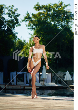 Pool is behind. Woman in white underwear 128591661
