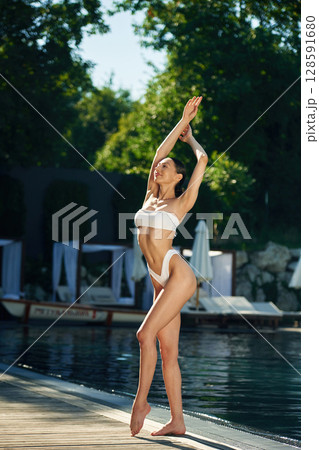 White underwear. Woman is standing near the pool White underwear. Woman is standing near the pool 128591680