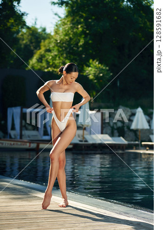White underwear. Woman is standing near the pool 128591682