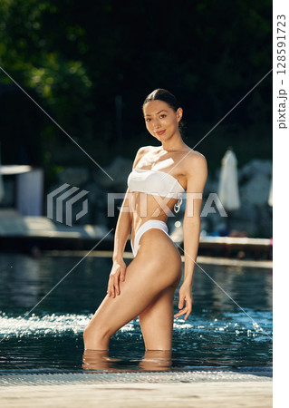 In white underwear. Woman is in the pool 128591723