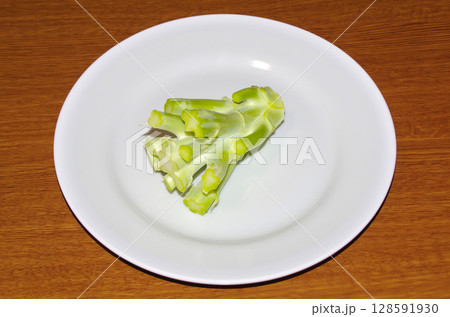 白い皿に乗せた生のブロッコリーの茎(木目背景) 白い皿に乗せた生のブロッコリーの茎(木目背景) 128591930