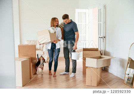 New home to live. Young couple with dog are moving to appartment New home to live. Young couple with dog are moving to appartment 128592330