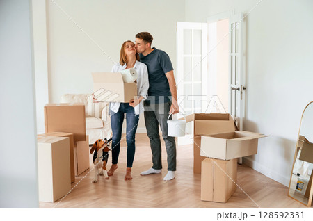 New home to live. Young couple with dog are moving to appartment 128592331
