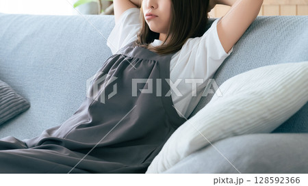 リビングのソファに座って考える女性 リビングのソファに座って考える女性 128592366