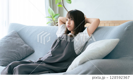 リビングのソファに座って考える女性 128592367