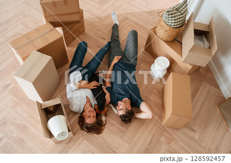 View from the top, lying down and resting. Young couple with dog are moving to new home View from the top, lying down and resting. Young couple with dog are moving to new home 128592457