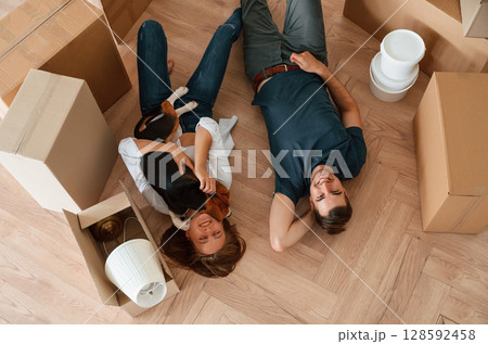 View from the top, lying down and resting. Young couple with dog are moving to new home View from the top, lying down and resting. Young couple with dog are moving to new home 128592458