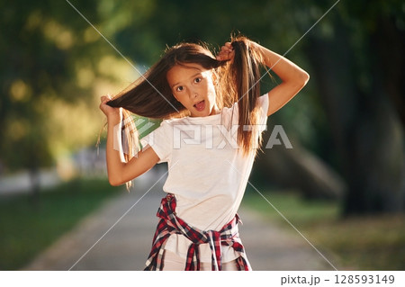 Playful emotions, having fun. Young girl in casual clothes is in the public park outdoors 128593149