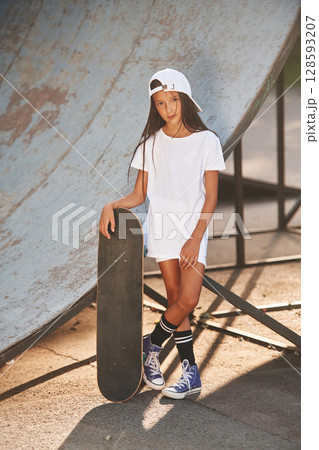 Conception of extreme sports. Happy little girl with skateboard outdoors 128593207
