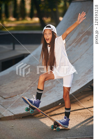 Conception of extreme sports. Happy little girl with skateboard outdoors 128593218