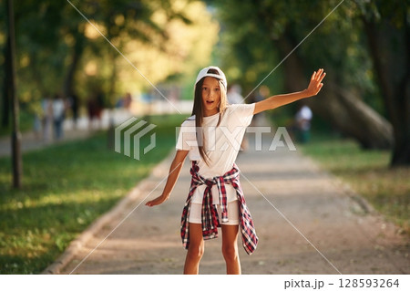 Young girl in casual clothes is in the public park outdoors 128593264