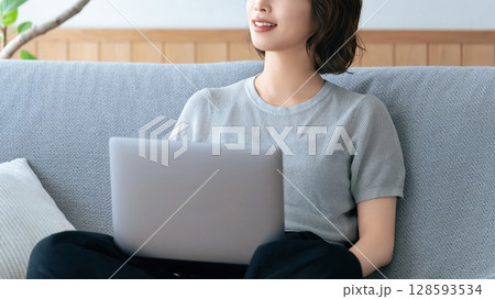 ソファに座ってパソコンを使う女性 ソファに座ってパソコンを使う女性 128593534