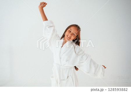 Young female kid is standing against white background Young female kid is standing against white background 128593882