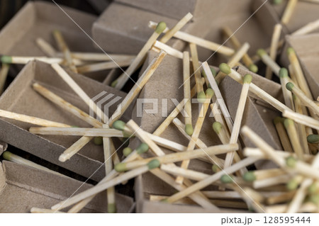 Chaotically scattered wooden matches without matchboxes on the table, a large number of wooden matches scattered in a large pile 128595444