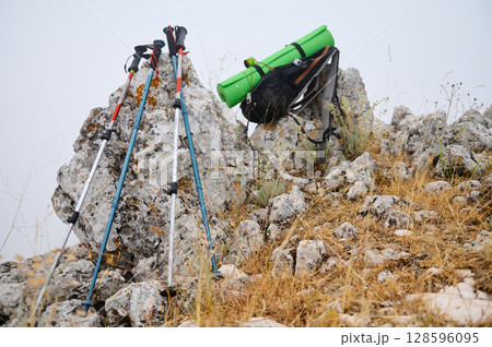 Hiking Gear and Trekking Poles on Rocky Terrain Outdoors 128596095