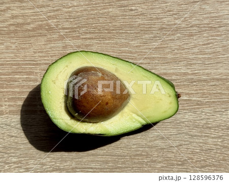 juicy ripe avocado cut in half on a monochrome background. High quality photo 128596376