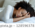 Woman Experiencing Emotional Distress While Lying on Bed in a Cozy Indoor Setting 128596378
