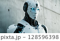 Futuristic Humanoid Robot With Glowing Blue Eyes Stands Against a Concrete Wall in a Modern Setting 128596398