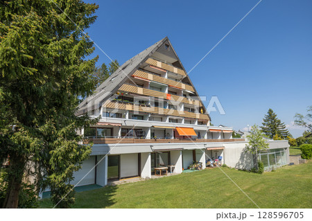 Charming residential house in Germany captured on a sunny summer day. garden, green lawn, and vibrant blue sky in the background 128596705