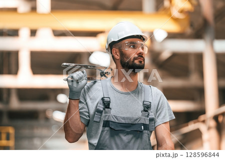 Handsome man. Young factory worker in grey uniform Handsome man. Young factory worker in grey uniform 128596844