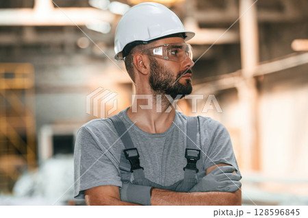 Handsome man. Young factory worker in grey uniform Handsome man. Young factory worker in grey uniform 128596845
