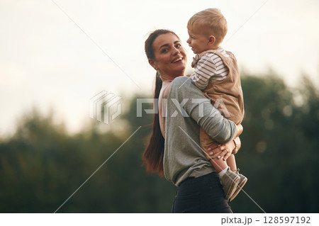 On the field. Mother is with her little baby son are outdoors together 128597192