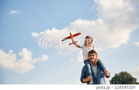 With aviator glasses, playing with toy plane. Father and little son are having fun outdoors 128597207