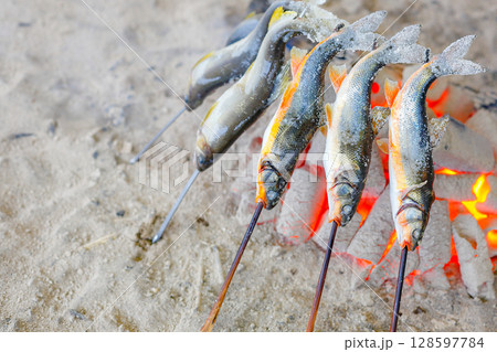 炭火で焼く鮎の串焼き 128597784