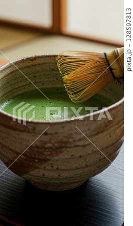 Japanese matcha green tea preparation with a traditional bamboo whisk in a ceramic chawan bowl Japanese matcha green tea preparation with a traditional bamboo whisk in a ceramic chawan bowl 128597813