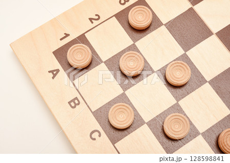 Wooden checkers on the board. The board game checkers. Wooden checkers on the board. The board game checkers. 128598841