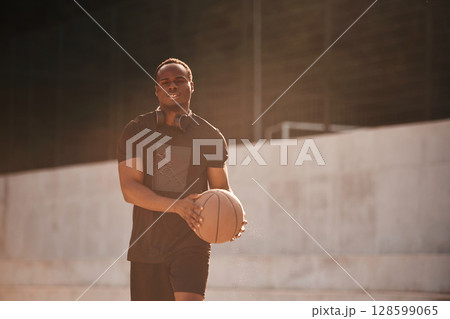 Holding ball in hands. Young black man Holding ball in hands. Young black man 128599065
