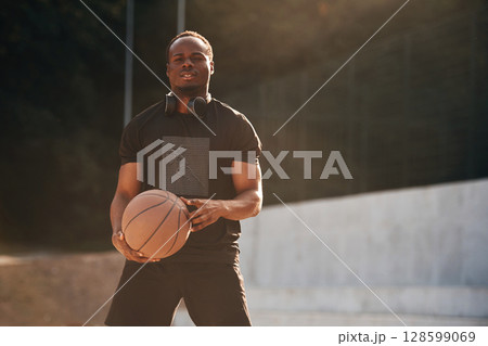 Photo in motion. Young black man is with basketball ball outdoors Photo in motion. Young black man is with basketball ball outdoors 128599069