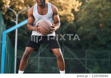 Front view. Young black man is with basketball ball outdoors 128599080