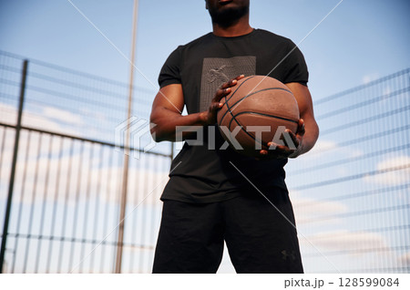 Natural lighting. Young black man is with basketball ball outdoors 128599084