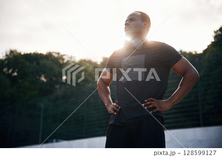 Beautiful sunlight. Handsome black man is posing outdoors at daytime 128599127