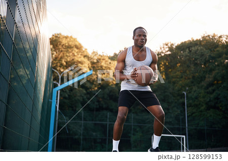 Photo in motion. Young black man is with basketball ball outdoors Photo in motion. Young black man is with basketball ball outdoors 128599153