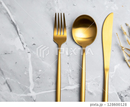 Gold Cutlery on Marble Background 128600128