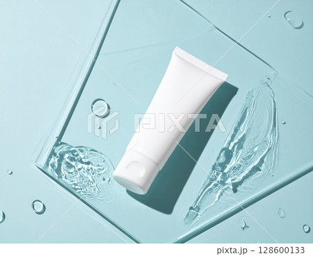 White Cosmetic Tube on Blue Background with Water Droplets 128600133