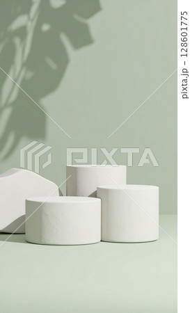 White Cylindrical Podiums on Pastel Green Background 128601775