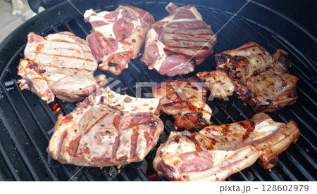 Juicy barbecue meat on the grill, close view, summer barbecue bliss background 128602979