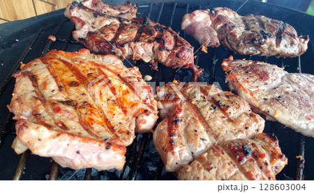 Juicy barbecue meat on the grill, close view, summer barbecue bliss background Juicy barbecue meat on the grill, close view, summer barbecue bliss background 128603004