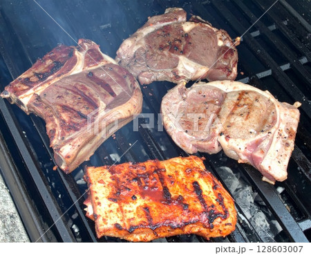 Juicy barbecue meat on the grill, close view, summer barbecue bliss background Juicy barbecue meat on the grill, close view, summer barbecue bliss background 128603007