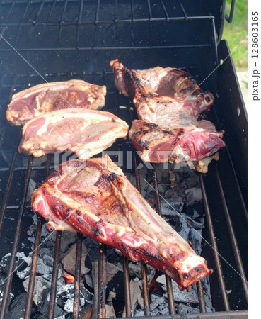 Juicy barbecue meat on the grill, close view, summer barbecue bliss background 128603165
