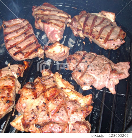 Juicy barbecue meat on the grill, close view, summer barbecue bliss background 128603205